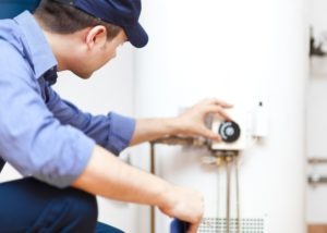 fall plumbing tip - plumber inspecting water heater